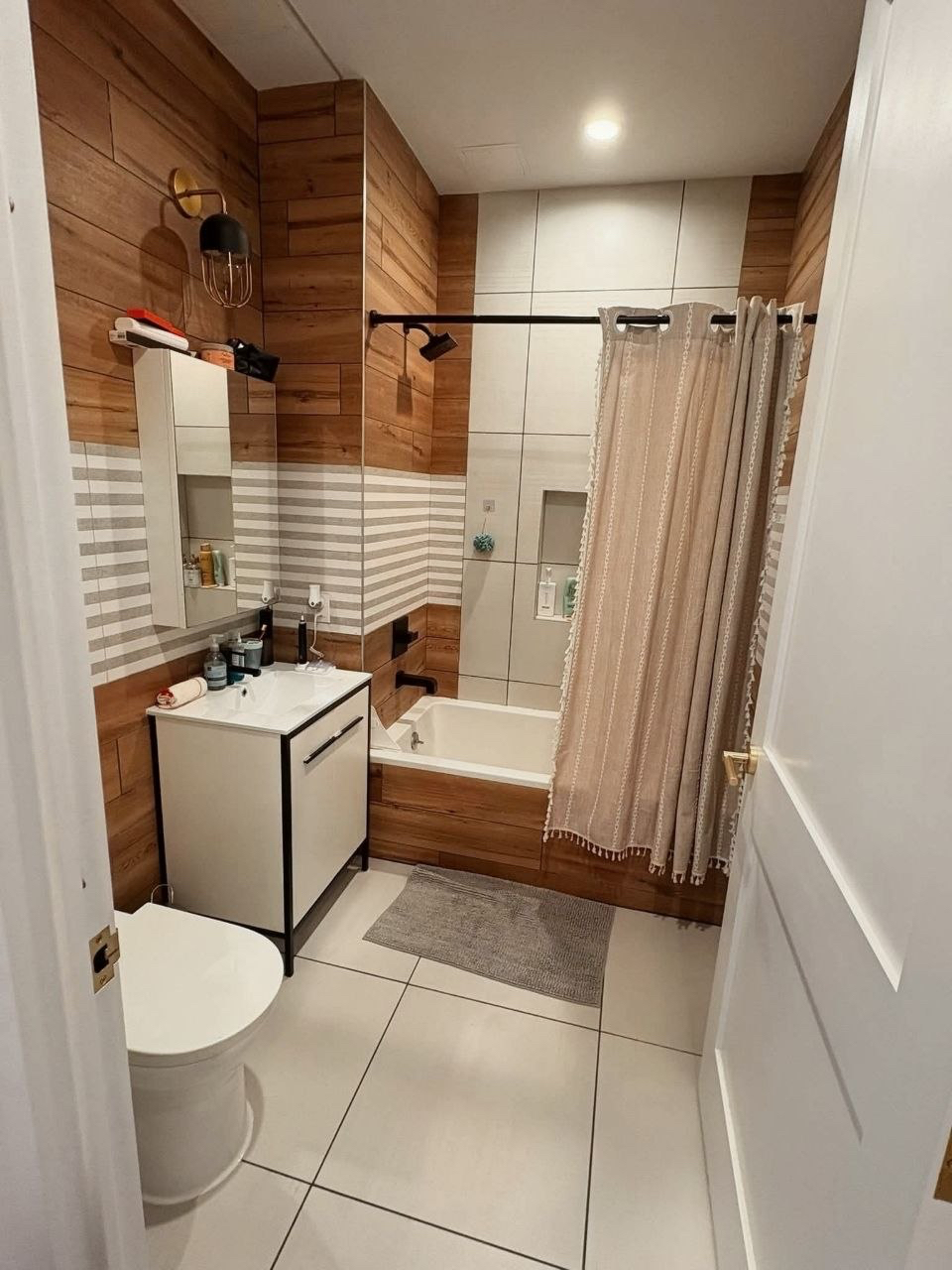 Bathroom with wood-effect tiles and bathtub.