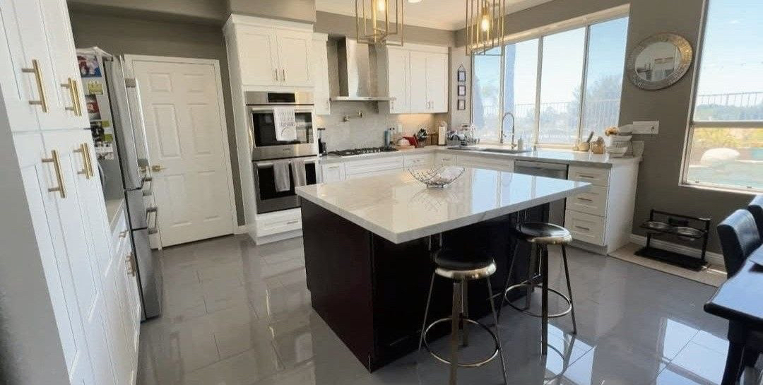 Bright kitchen with an island and polished floor.