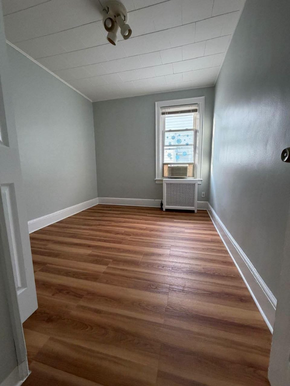 Empty bedroom with wood flooring.