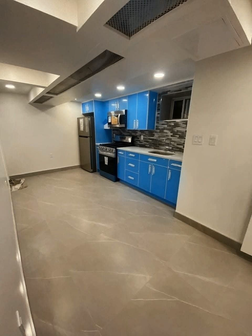 Kitchen with blue cabinets and tile flooring.
