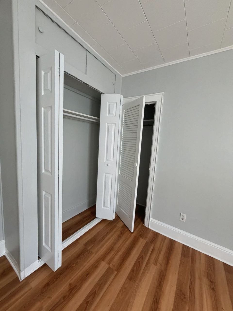 Empty bedroom closets with open doors.