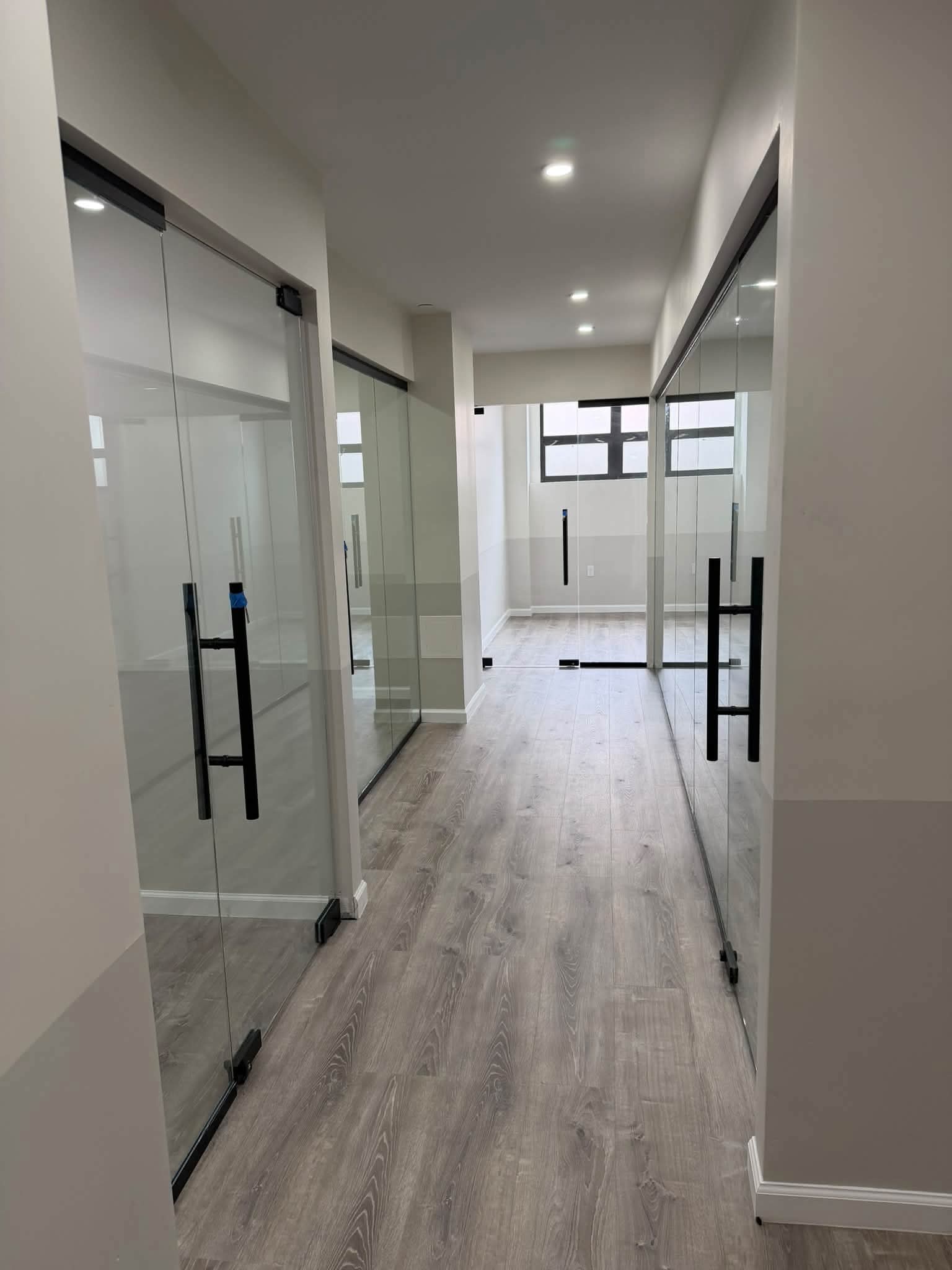 View along an office corridor with glass partitions.