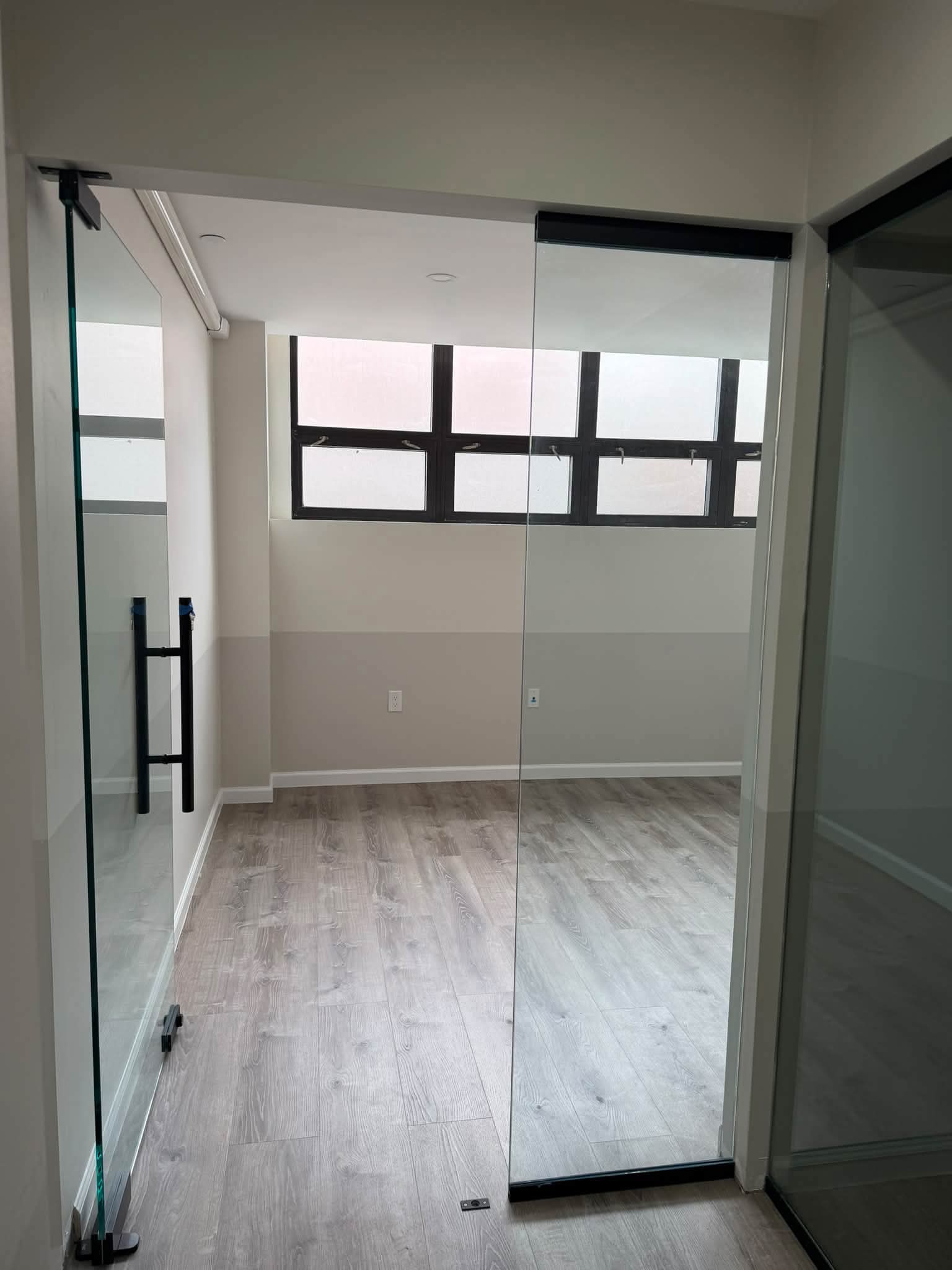 Office room with a glass door and large window.