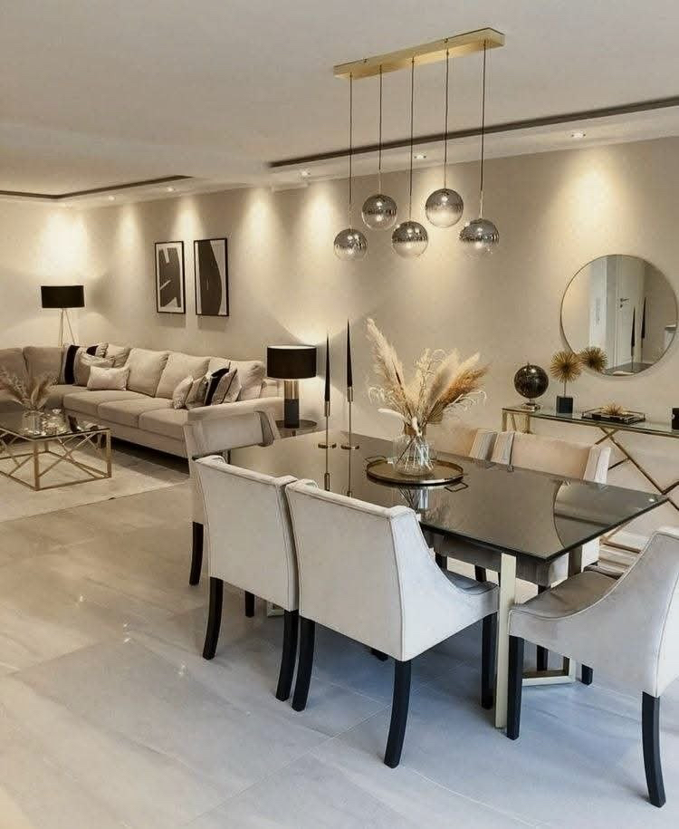 Living and dining room with cream seating and glass pendant lights.